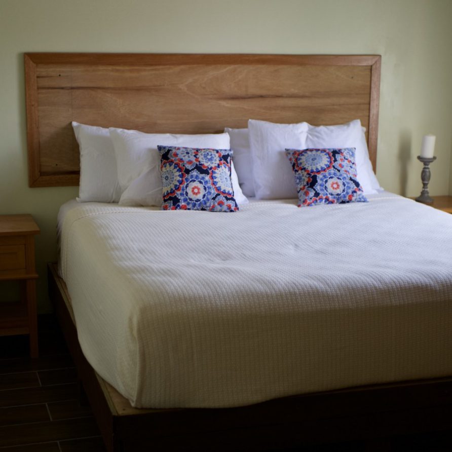 MeMe's Place Estate king bed with candles and patterned accent pillows