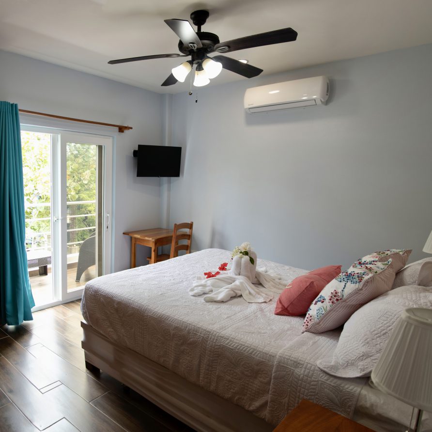 2BR Villa K+Q primary bedroom with king bed, blue accent wall and balcony