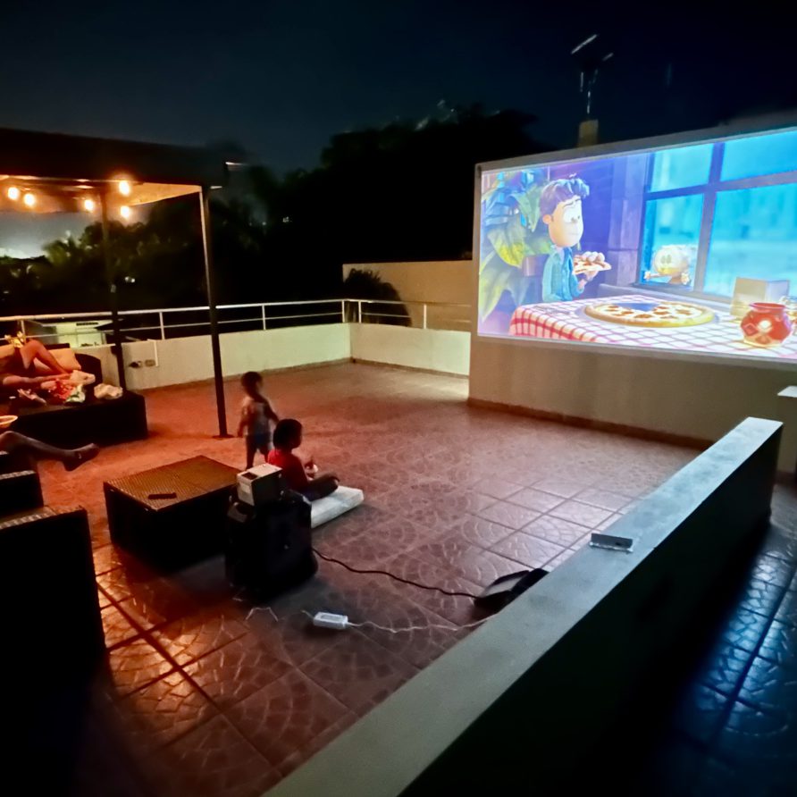 Outdoor movie night on the MeMe's Place Estate rooftop with projector screen