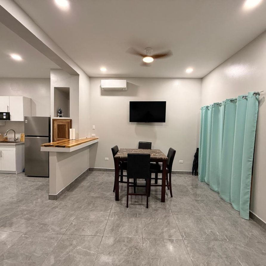 Honeycreeper Suite dining area with kitchen visible beyond