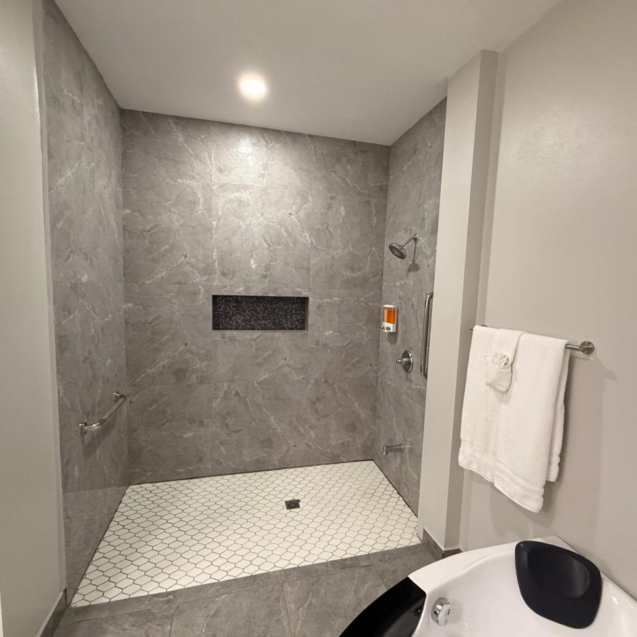 Honeycreeper Suite walk-in marble shower with corner bathtub