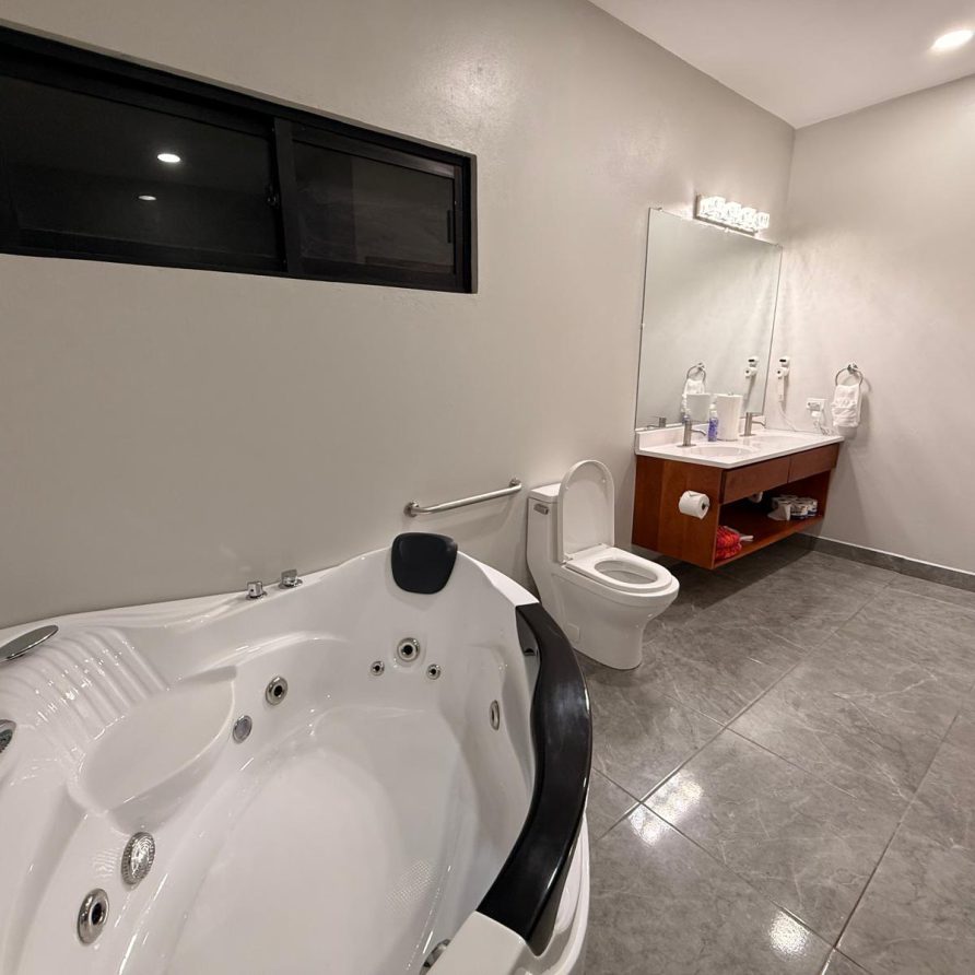 Honeycreeper Suite spacious bathroom with corner jacuzzi