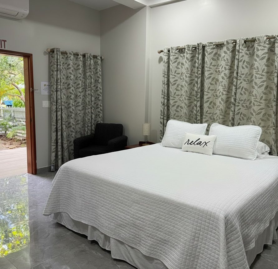 Toucan Room king bed with door open to outdoor grounds