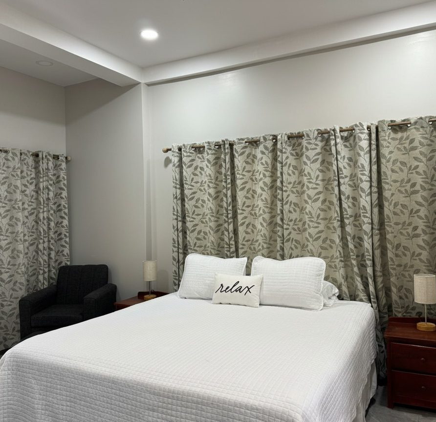 Toucan Room king bed with armchair and leaf-pattern curtains