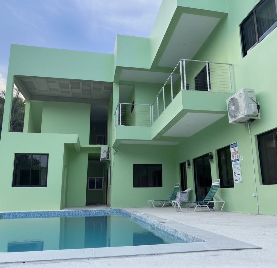 MeMe's Place pool and green building exterior at the property