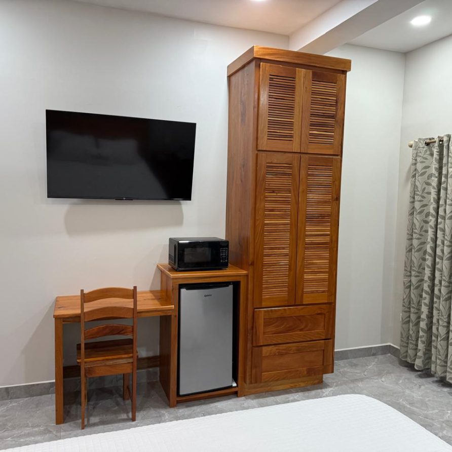 Toucan Room desk with mini-fridge, microwave and tall wooden wardrobe