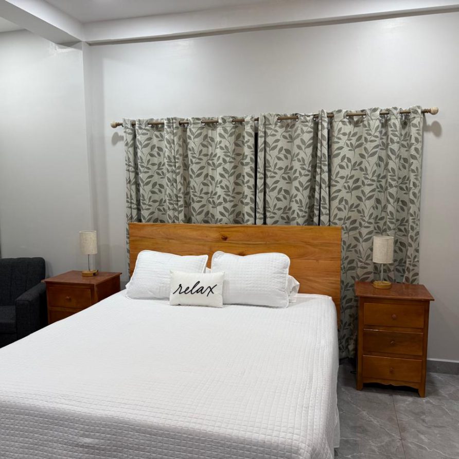 Toucan Room queen bed with leaf-pattern curtains and reading chair