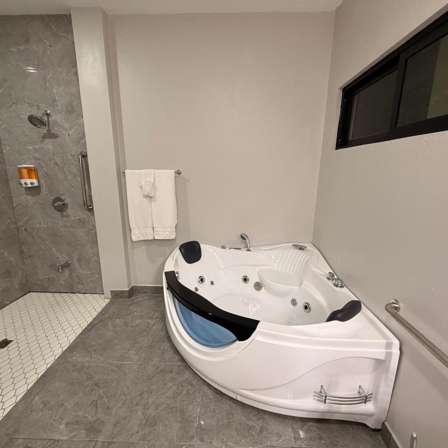Honeycreeper Suite signature bathroom with corner jacuzzi and walk-in shower